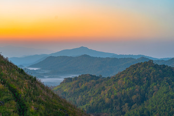 Obraz premium scenery sunrise above the mountain ridge on Doi Pha Phung at Nan province in Thailand.