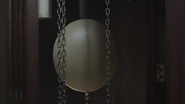 A swinging clock pendulum in SLOW MOTION.