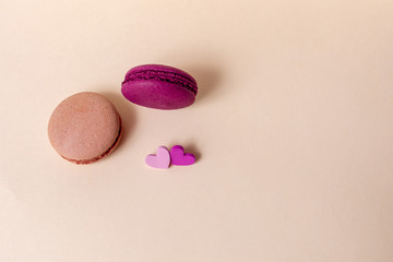 Beige and red macaroons with hearts on are a light background. Greeting card Valentine's day. Flat lay. Copy space.