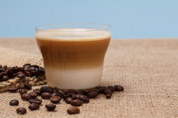 Coffee cappuccino and coffee beans on sackcloth background
