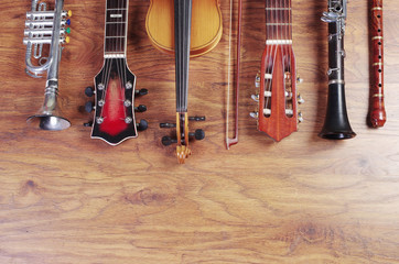 Naklejka premium Musical instruments on a wooden textured background. Block flute, violin, guitar, electric guitar, trumpet