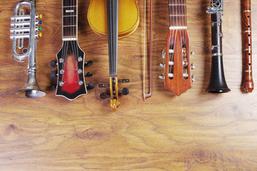Naklejka premium Musical instruments on a wooden textured background. Block flute, violin, guitar, electric guitar, trumpet