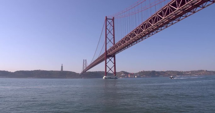 Lisbon bridge and Christ the King shot on a moving boat. Travel shot.