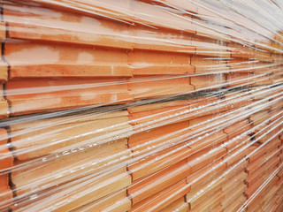 Orange bricks wrapped in plastic wrap. Construction material.