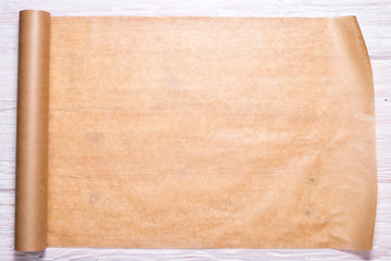 Roll of baking paper on wooden background