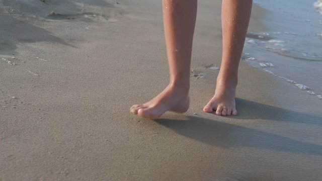 Legs walk on wet beach.