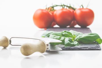 Frische Tomaten, Basilikum auf einem Holzbrett, italienische Vorspeisen kommen immer gut an. 
