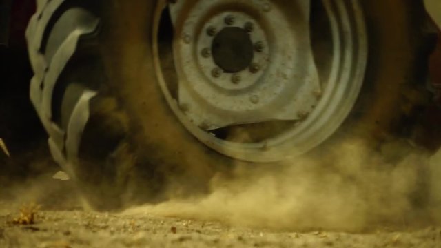 A tractor ploughing in a dusty field
