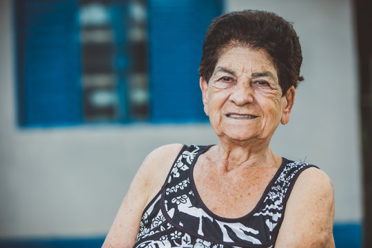 Portrait of smiling beautiful older female farmer. Woman at farm in summer day. Gardening activity. Brazilian elderly woman.