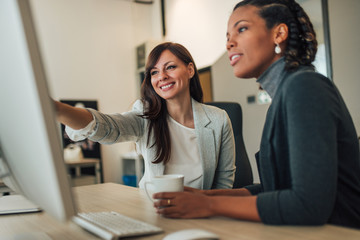 Two beautiful women working together in the office.
