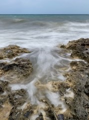 Long exposure of waves and rock pools against coast line rocks 