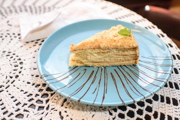 Napoleon cake on the table in a cozy chocolate bar. Tasty and not healthy food.