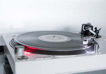 modern white Turntable vinyl record player. on rotation. Sound technology for DJ to mix & play music. Vinyl record and needle.  - 312245637