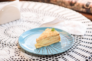 Napoleon cake on the table in a cozy chocolate bar. Tasty and not healthy food.
