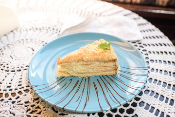 Napoleon cake on the table in a cozy chocolate bar. Tasty and not healthy food.