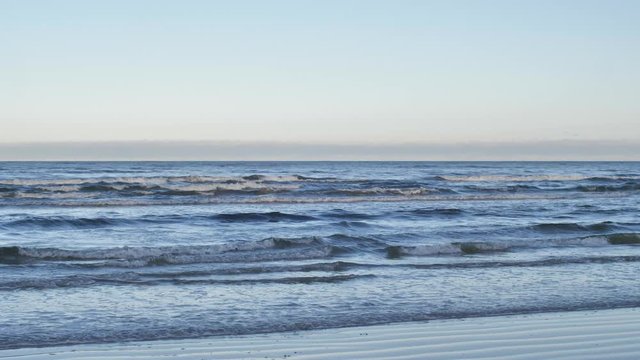 Europe, Latvia, Jurmala. Waves on the Baltic Sea near the shore. Camera is moving from left to right showing panoramic view of the coastline and the sea.