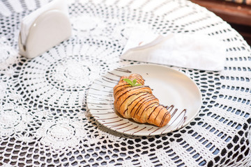 Chocolate croissant on the table in a cozy chocolate bar. Tasty and easy food.