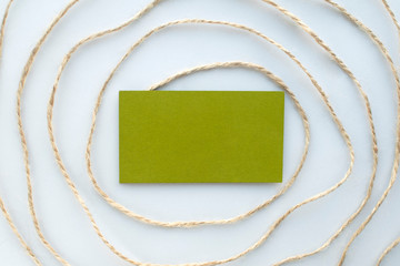 Zero waste background with jute thread circle pattern at gray background and green paper note. Eco-friendly materials.