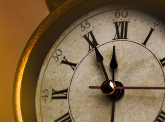 Golden vintage alarm clock showing five to twelve