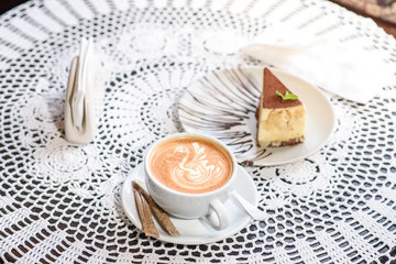 Coffee and Philadelphia cheesecake on a table in a cozy chocolate bar. Tasty and easy food.