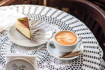 Coffee and Philadelphia cheesecake on a table in a cozy chocolate bar. Tasty and easy food.