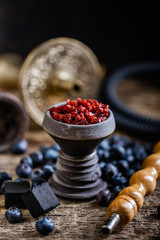 Stone hookah head on old rustic table with fruit flavoured tobacco