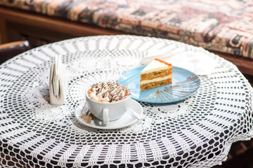 Carrot cake and marshmallow cappuccino on the table in a cozy chocolate bowl. Tasty and satisfying.