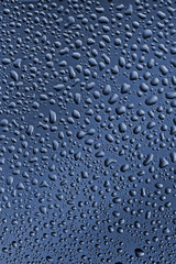 Misted glass, drops close-up on a rainbow background. The image is tinted in the color of the year-classic blue.
