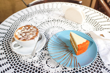 Carrot cake and marshmallow cappuccino on the table in a cozy chocolate bowl. Tasty and satisfying.