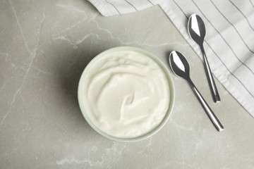 Tasty organic yogurt on grey marble table, flat lay