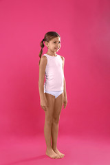 Obraz na płótnie Canvas Cute little girl in underwear on pink background