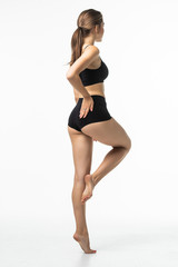 Rear view of young pretty woman with perfect body wear in black underwear isolated on white background