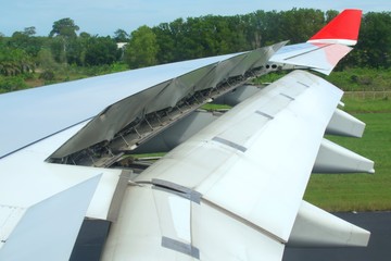 Jet plane air brakes and flaps fully extended after landing. Hydraulic actuators can be seen in the...