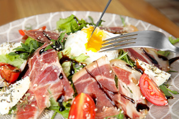 Delicious prosciutto salad with vegetables on plate, closeup