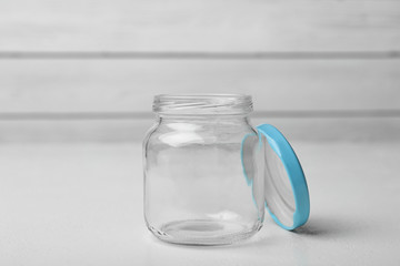 Open empty glass jar on white table