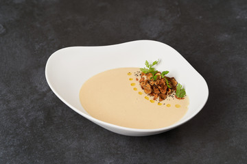 Cream Soup with bream fish on gray background with copy space, close-up
