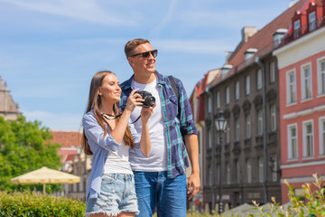 Couple of tourists traveling and exploring beautiful old town together. Loving man and woman in a vacation trip.