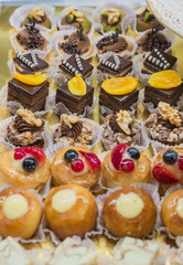 Pastry shop display window with variety of mini desserts and cakes, selective focus
