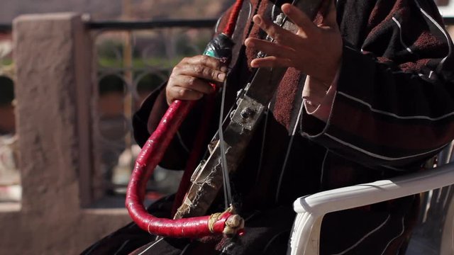 Closeup of berber musicians fingers playing the rabab in Taffraoute, Morocco.