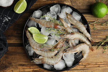Flat lay composition with raw shrimps on wooden table
