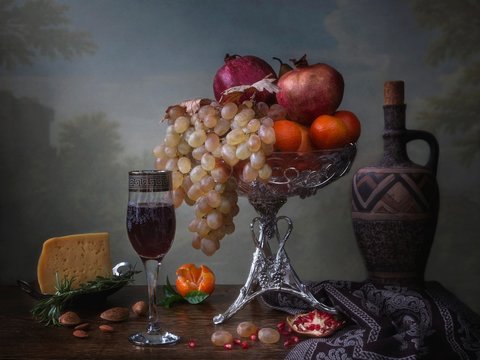 Still life with glass of wine and grapes on wooden background