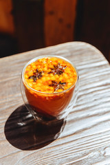 Sea buckthorn tea with orange in a glass cups with fresh sea buckthorn berries and leaves. Herbal vitamin tea.