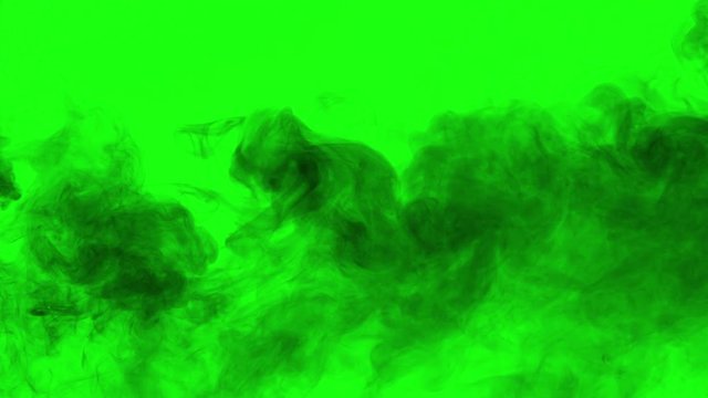 Black Smoke Curtain Slowly Flows. A rare stream of black smoke on a green chroma key slowly fills the screen