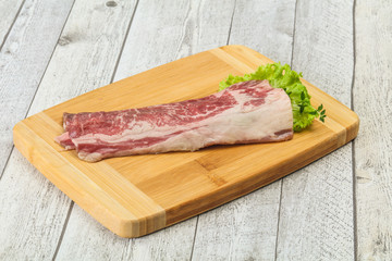 Raw beef bacon over wooden board