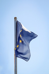 eine Eurofahne flattert im Wind vor einem blauen Himmel