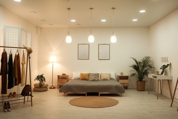Stylish interior of contemporary bedroom with different furniture