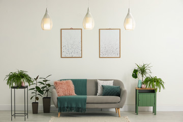 Soft pillows and plaid on grey sofa in living room