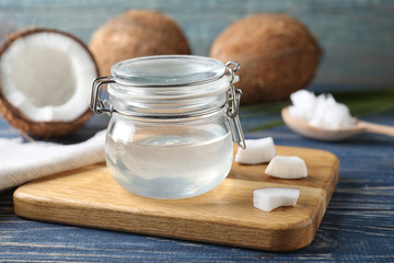 Coconut oil in jar on blue wooden table