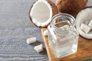 Coconut oil on grey wooden table, closeup, space for text