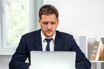 Shot  of a young serious man working on  laptop.